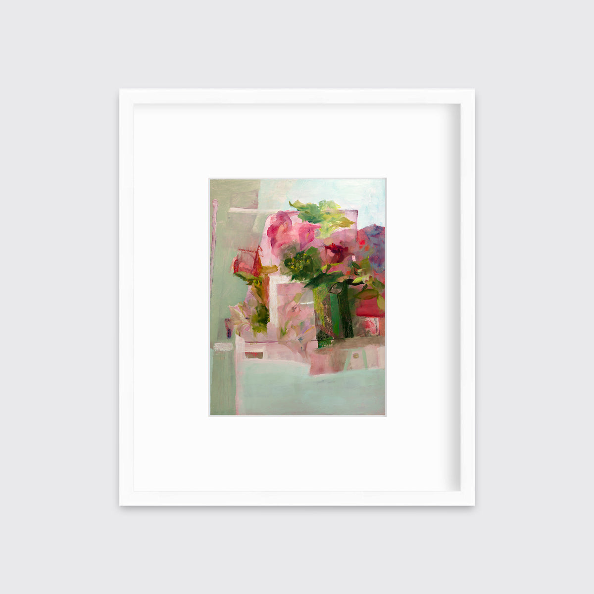 A pink, green and red abstract print in a white frame with a mat hangs on a white wall.