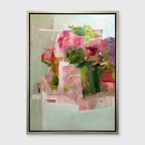 A pink, green and red abstract print in a silver floater frame hangs on a white wall.