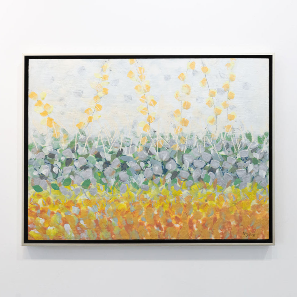 An abstract encaustic painting of gold and silver flowers is hung on a gallery wall.