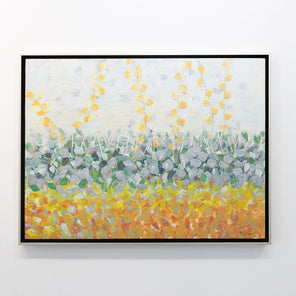 An abstract encaustic painting of gold and silver flowers is hung on a gallery wall.