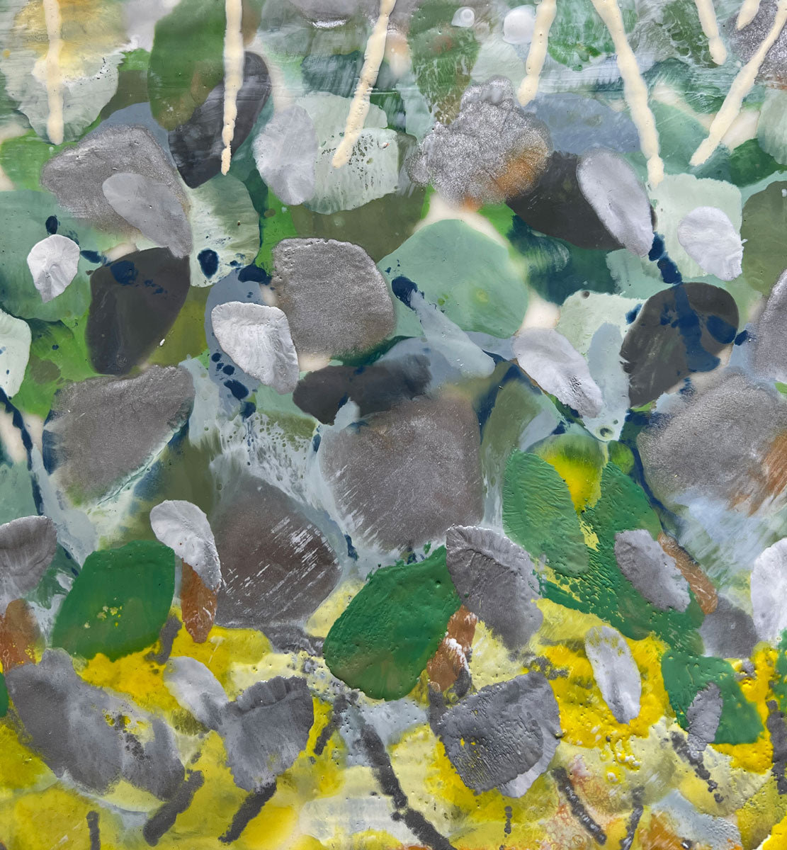 A detail shot of an abstract encaustic painting of gold and silver flowers.