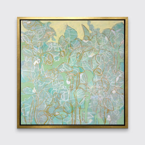 A green, yellow and white abstract print in a gold floater frame hangs on a white wall.