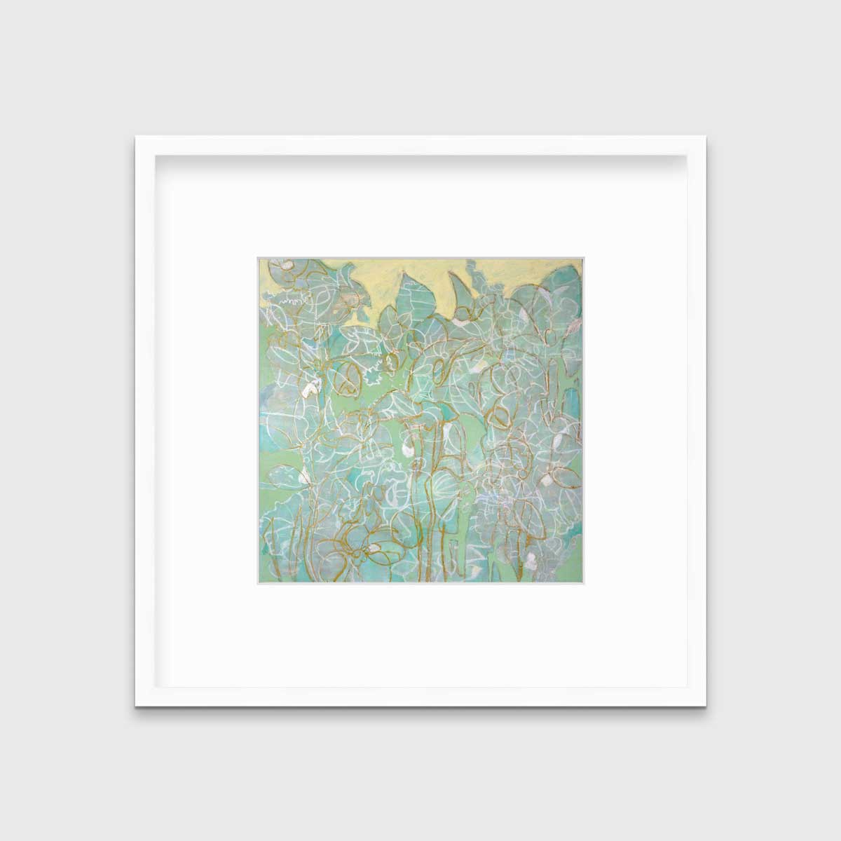 A green, yellow and white abstract print in a white frame with a mat hangs on a white wall.