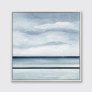 A blue and white abstract landscape in a white floater frame hangs on a white wall.