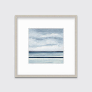 A blue and white abstract linear landscape print in a silver frame with a mat hangs on a white wall.