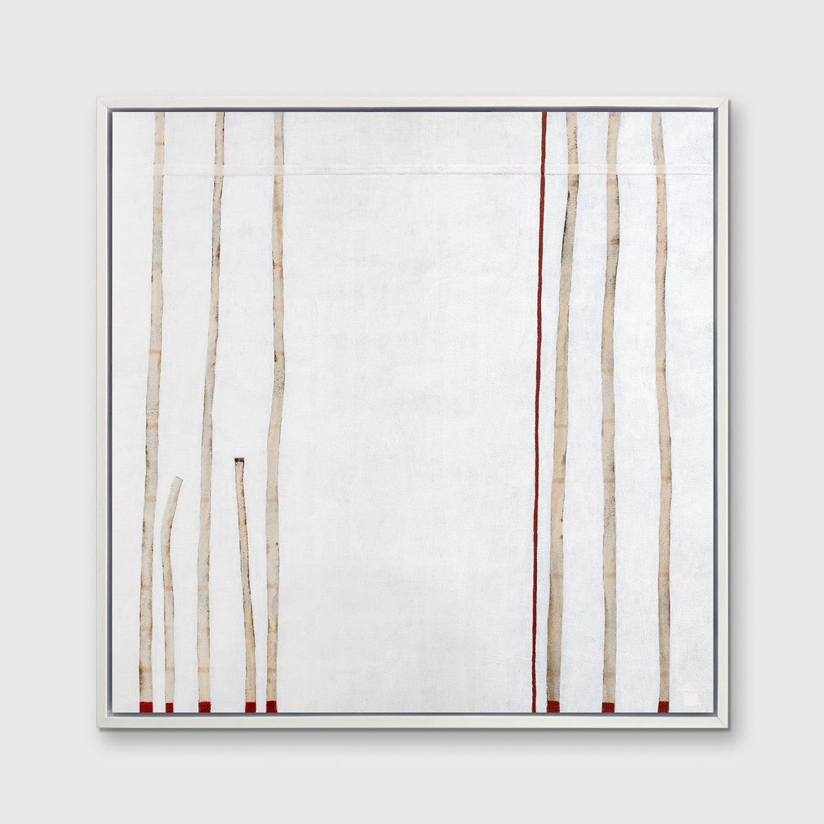 A white, beige and red abstract print in a white floater frame hangs on a white wall.