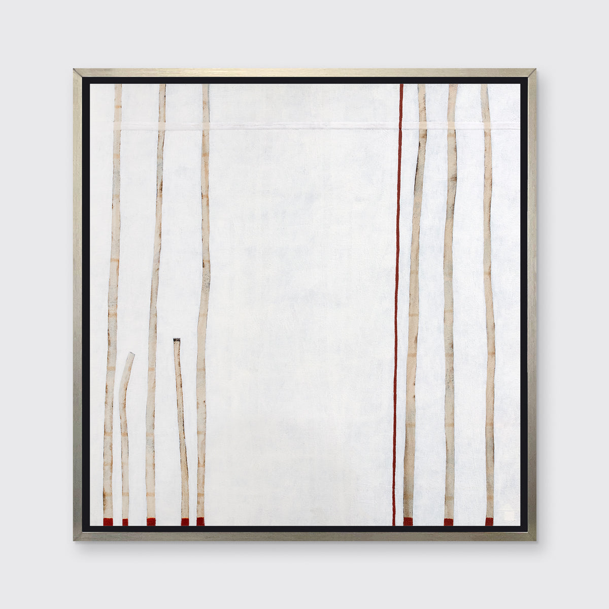 A white, beige and red abstract print in a silver floater frame hangs on a white wall.