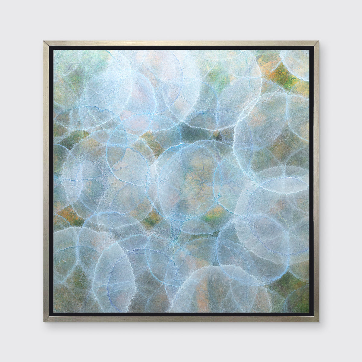 A light blue, green and yellow abstract geometric print in a silver floater frame hangs on a white wall.
