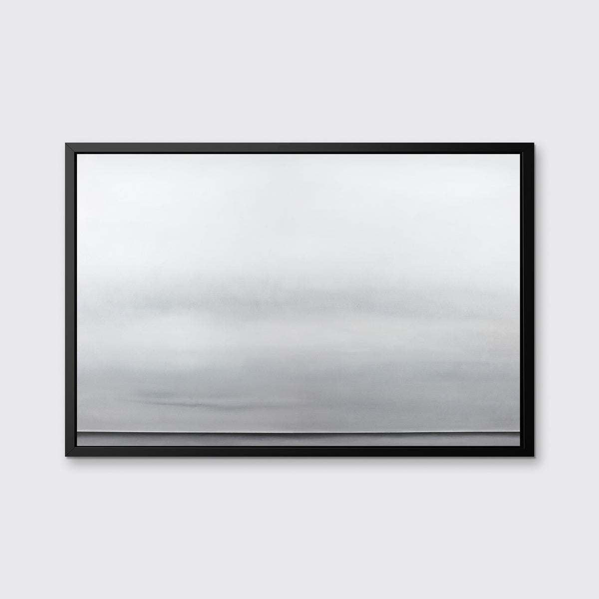 A tonal grey abstract landscape print in a black floater frame hangs on a white wall.