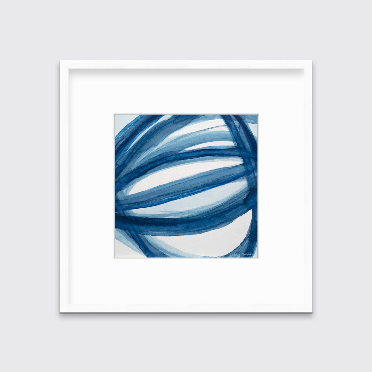 A blue and white abstract print in a white frame with a mat hangs on a white wall.