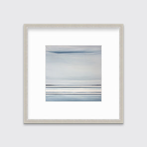 A blue and white linear abstract print in a silver frame with a mat on a white wall.