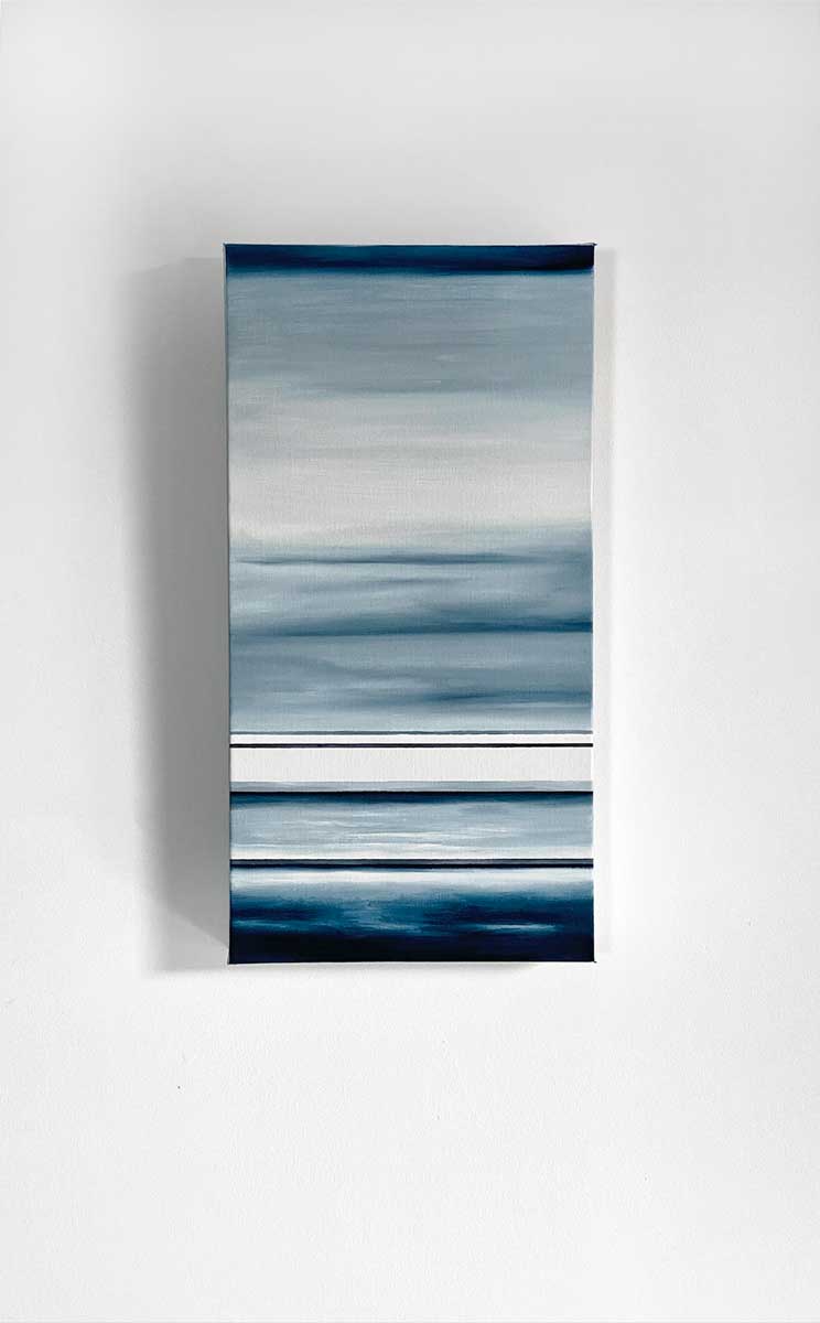 Different sized bands of hues of blue and white hanging on a white wall.