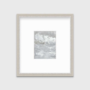 A white and grey abstract print in a silver frame with a mat hangs on a white wall.