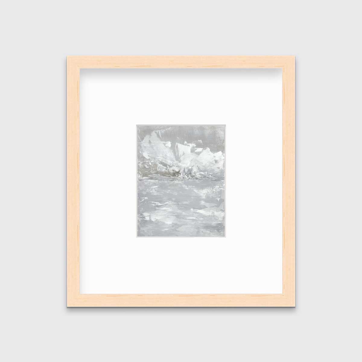 A white and grey abstract print in a natural wood frame with a mat hangs on a white wall.