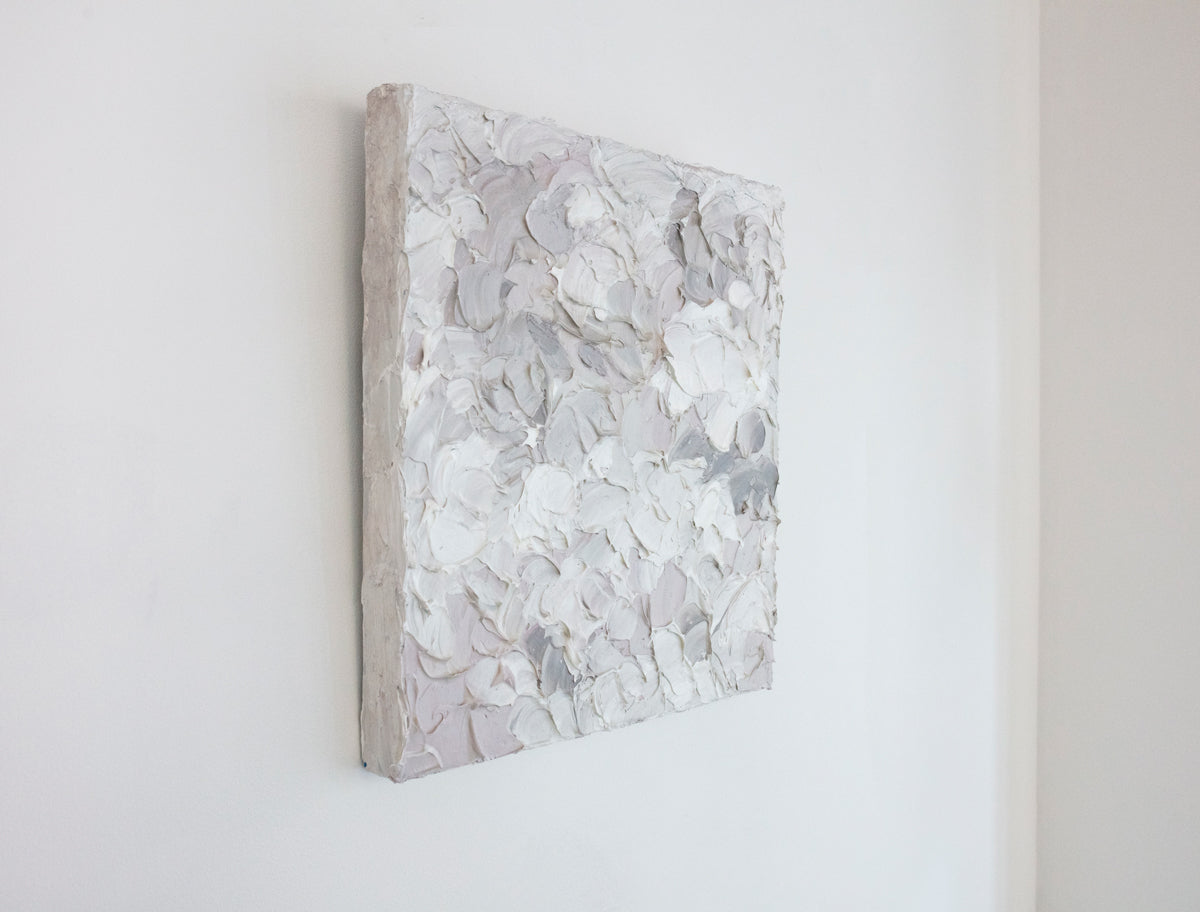 A left angle view of a small abstract painting by Teodora Guererra. It hangs on a white gallery wall.
