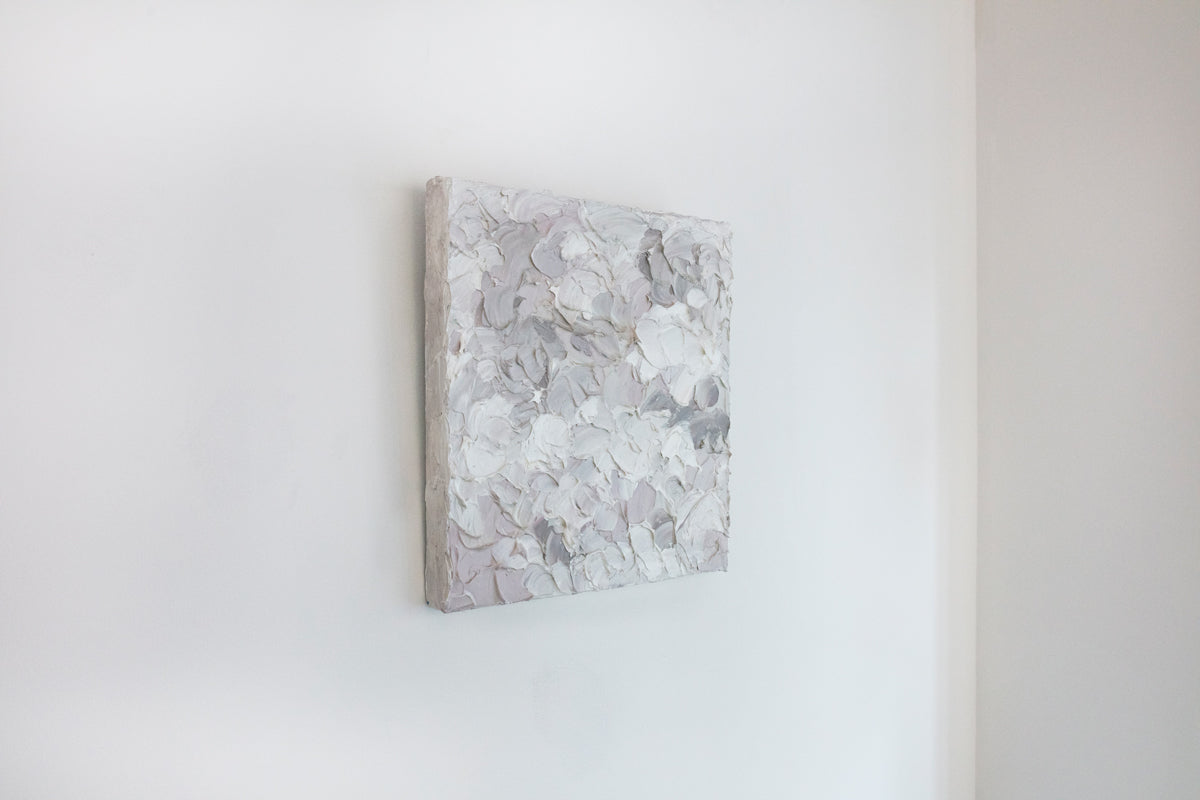 A left angle view of a small abstract painting by Teodora Guererra. It hangs on a white gallery wall.