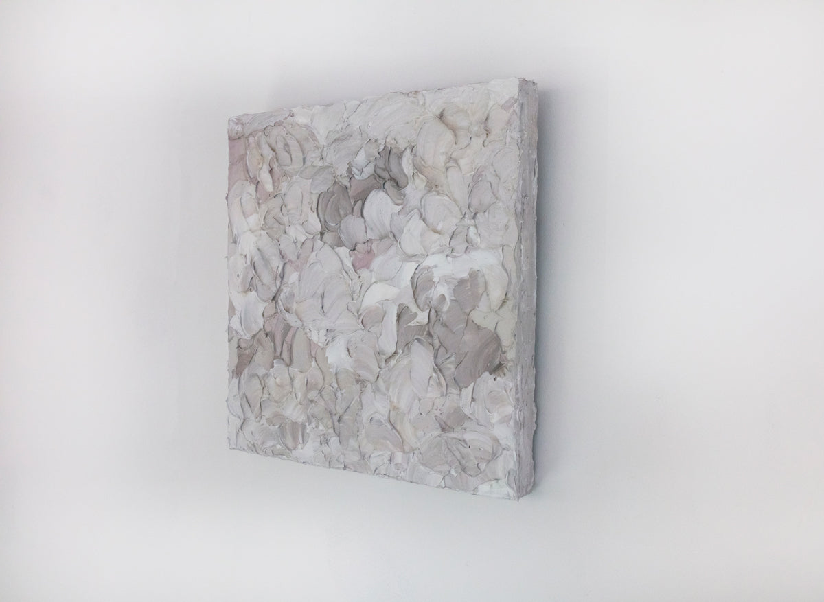 A right angle view of a small abstract painting by Teodora Guererra. It hangs on a white gallery wall.