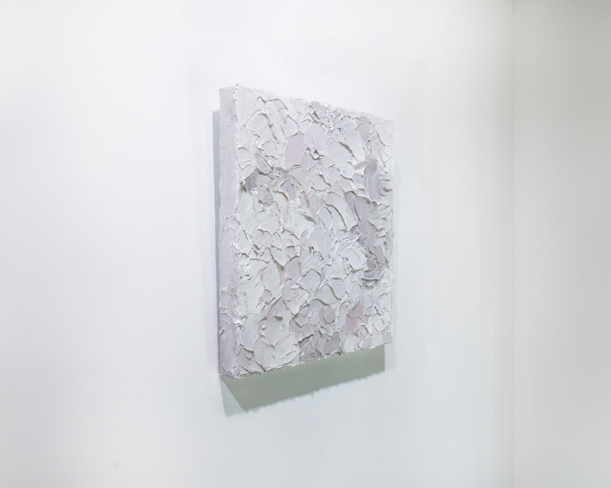 A left angle view of a small abstract painting by Teodora Guererra. It hangs on a white gallery wall.