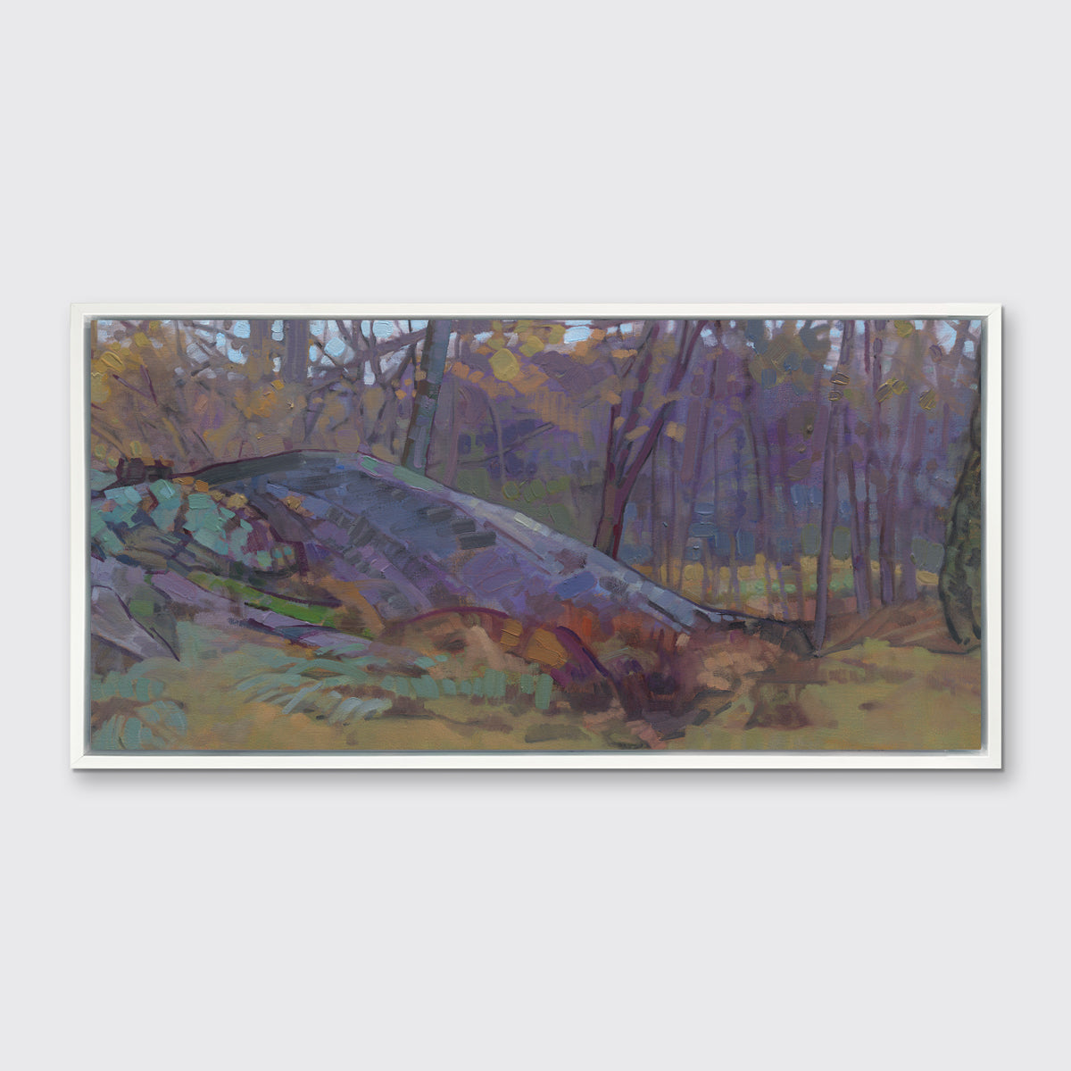 A muted multicolored abstract landscape print in a white floater frame hangs on a white wall.