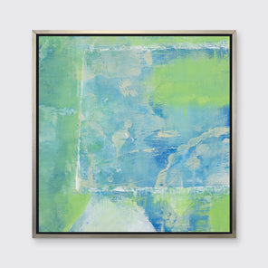 A blue, green and white abstract print in a silver floater frame hangs on a white wall.