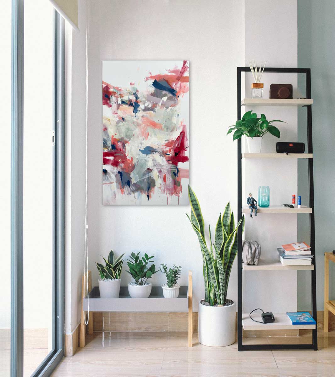 A red and white abstract painting by Kelly Rossetti hangs on a white wall above a low shelf with three potted plants, a potted floor plant and a ladder shelf with accessories.