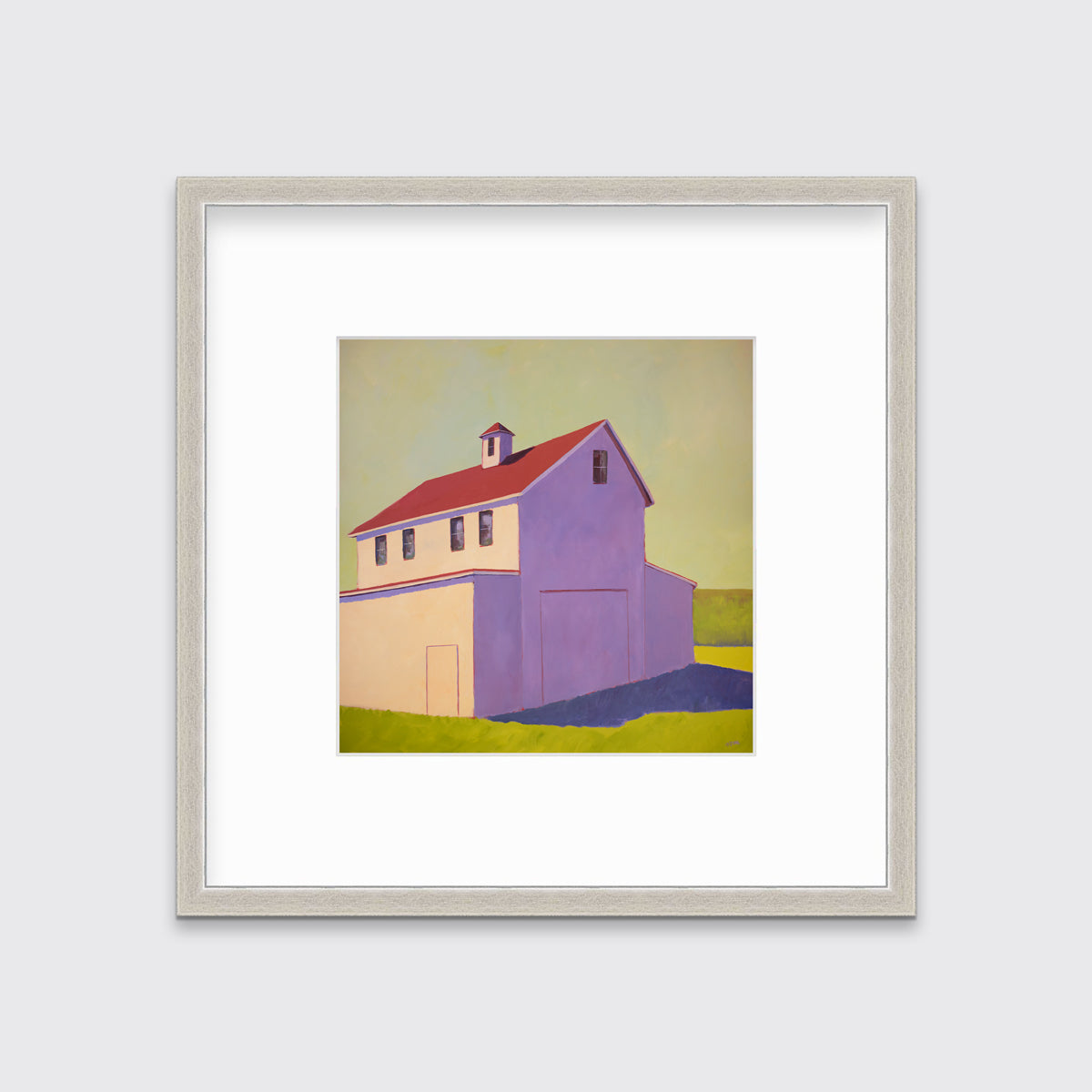 A contemporary barn print in a silver frame with a mat hangs on a white wall.