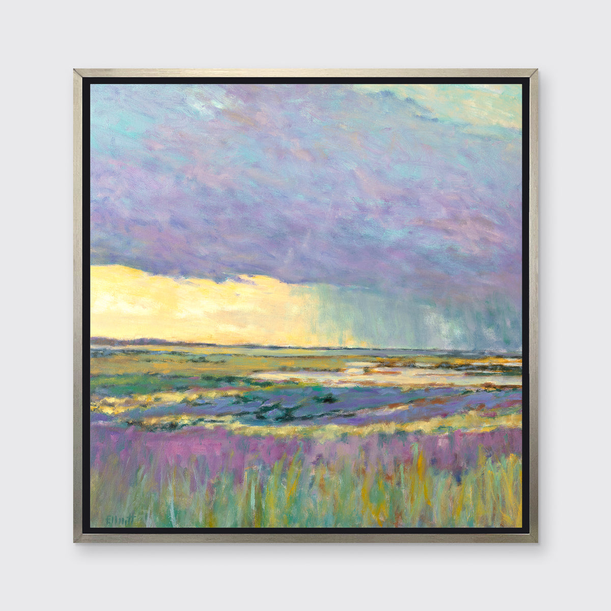 A multicolored abstract landscape print in a silver floater frame hangs on a white wall.