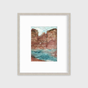 A teal, brown and black abstract landscape print in a silver frame with a mat hangs on a white wall.