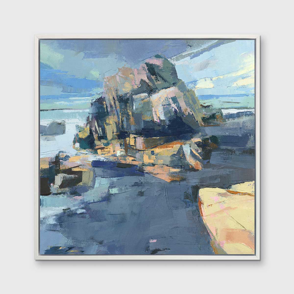 A blue, green and yellow abstract landscape print in a white floater frame hangs on a white wall.