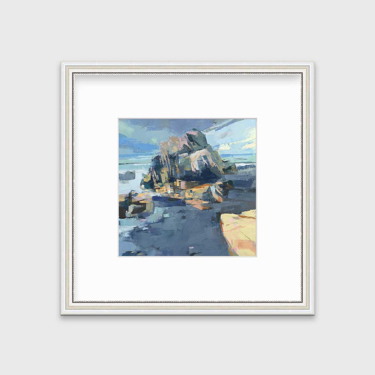 A blue, green and yellow abstract landscape print in a white frame with antiqued beading with a mat hangs on a white wall.
