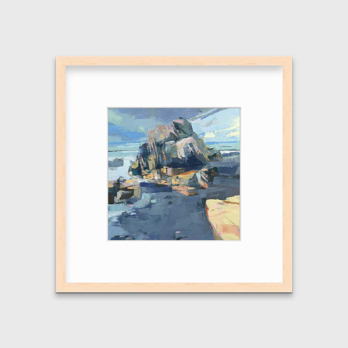 A blue, green and yellow abstract landscape print in a natural wood frame with a mat hangs on a white wall.