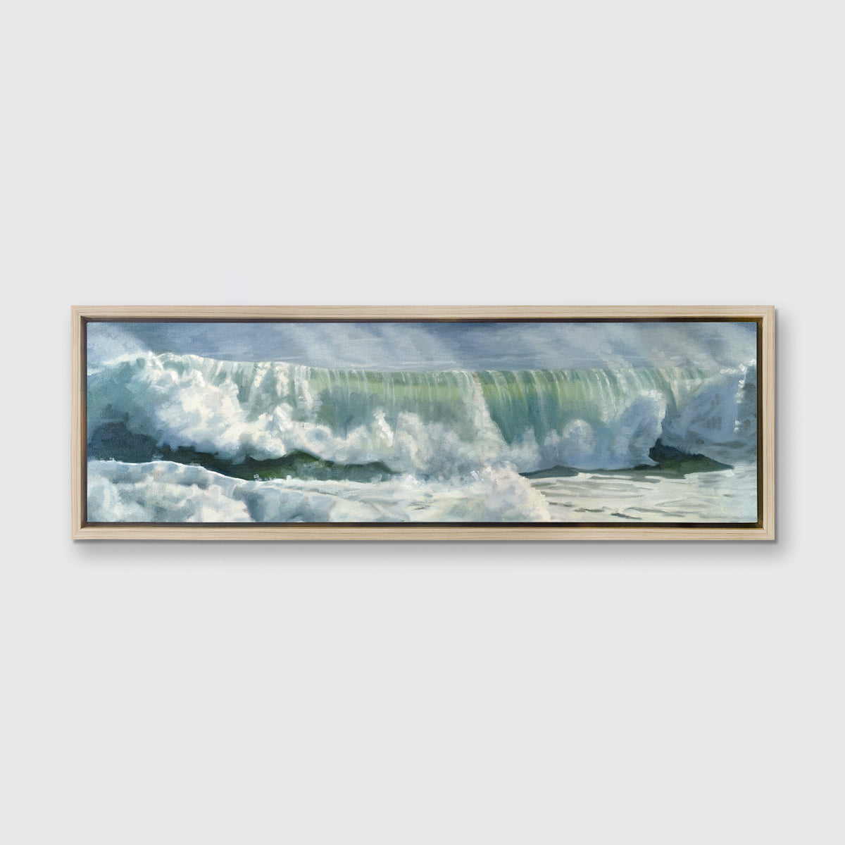 A blue, white and green abstract rolling wave coming to shore print in a white oak wood floater frame hangs on a white wall.