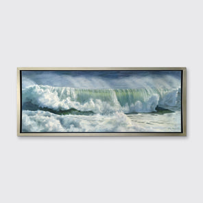A blue, white and green abstract rolling wave coming to shore print in a silver floater frame hangs on a white wall.
