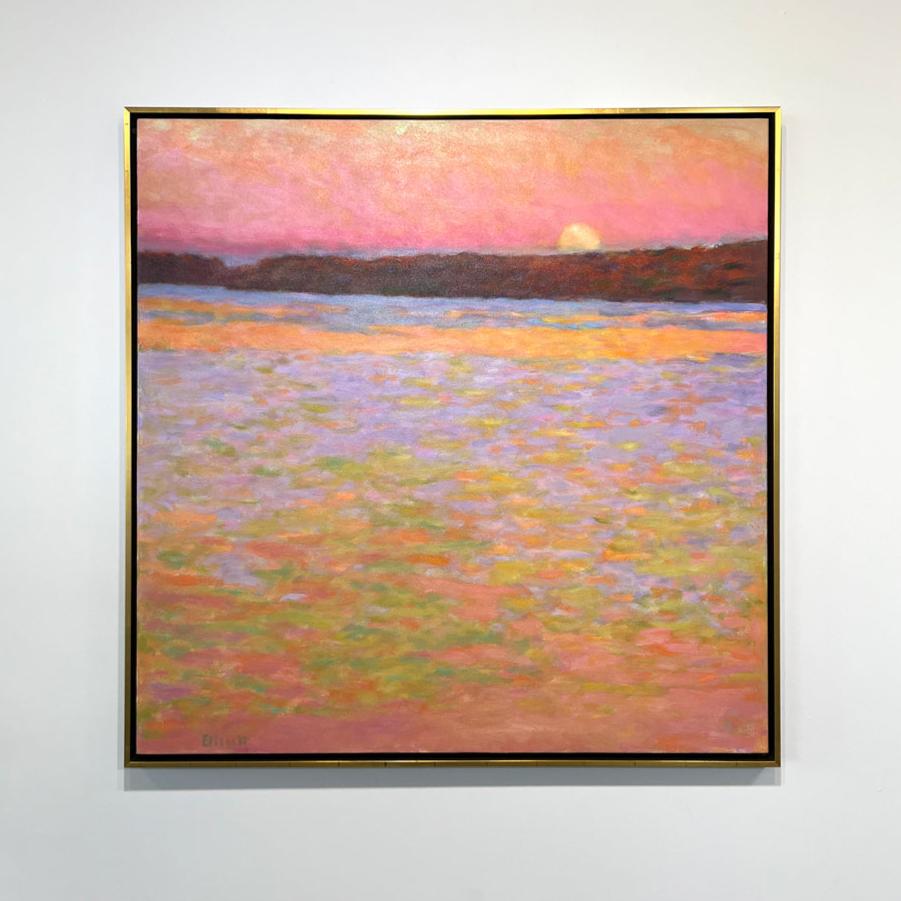 Framed painting of a sunset over water with a colorful sky hanging on a white wall.
