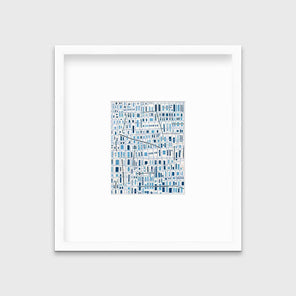 A blue and white geometric abstract print in a white frame with a mat hangs on a white wall.