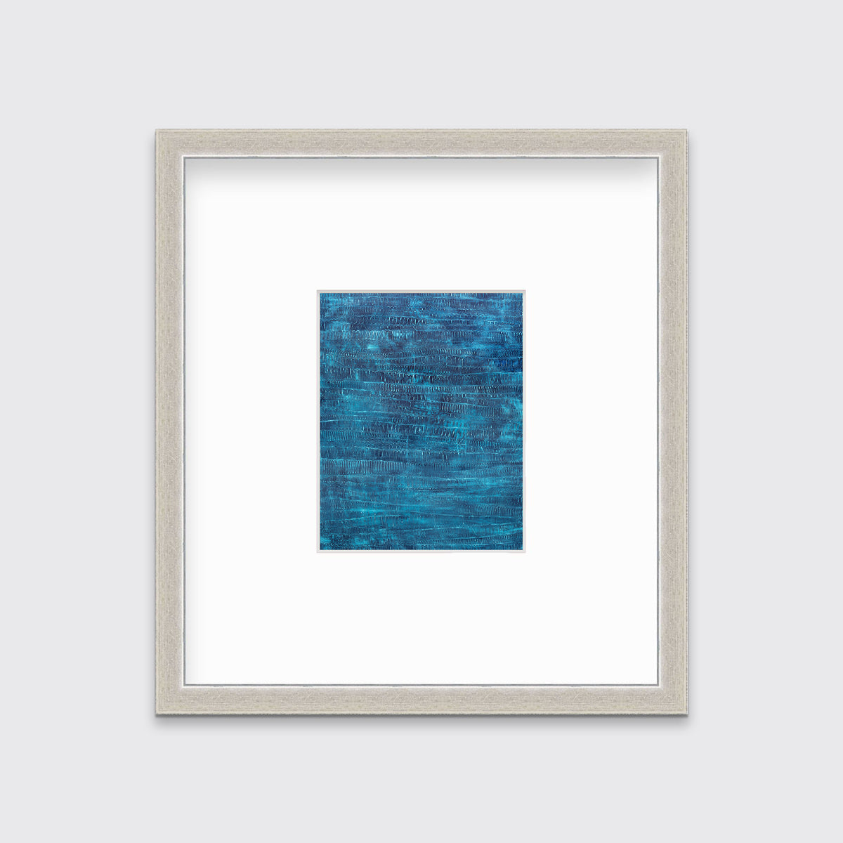 A dark teal abstract print in a silver frame with a mat hangs on a white wall.