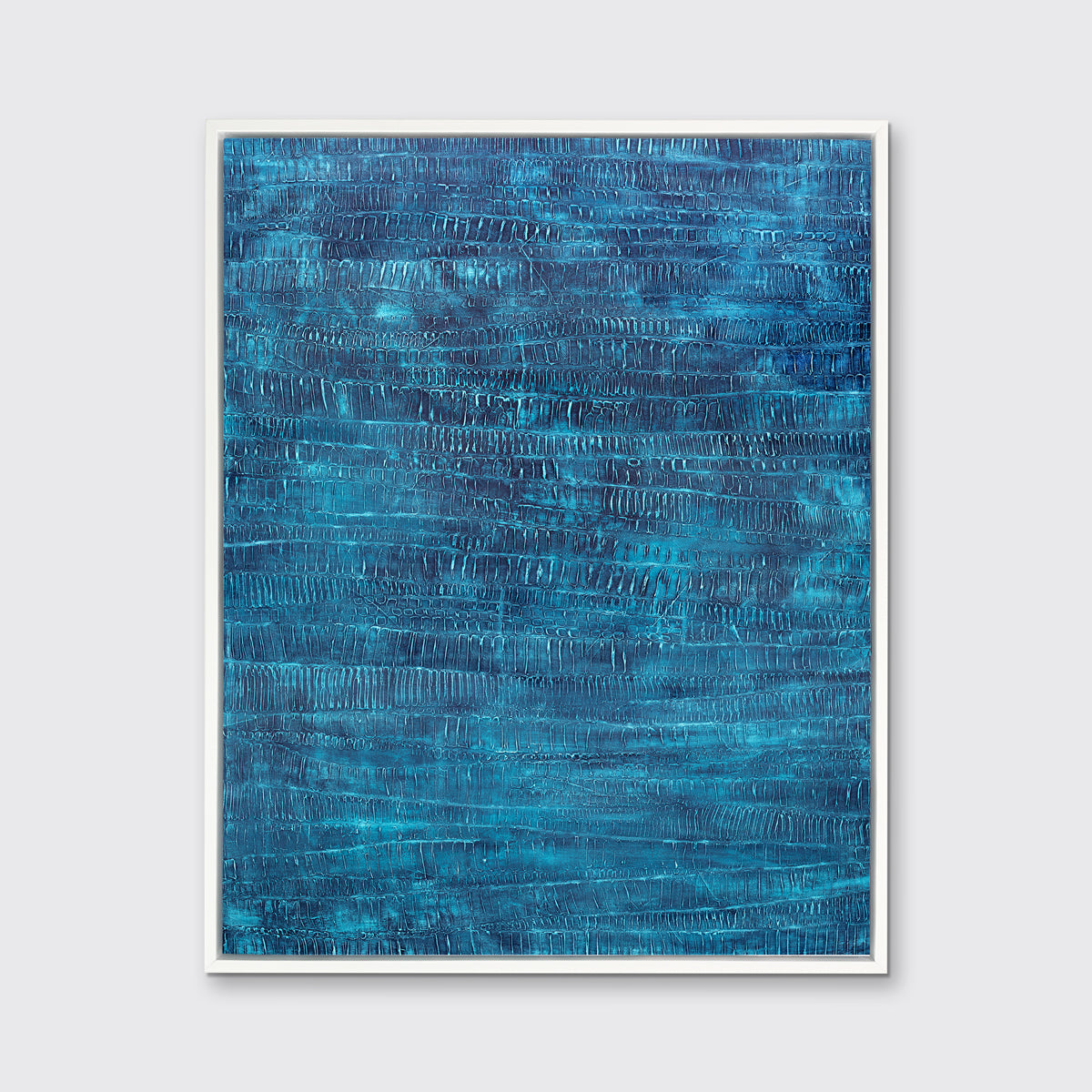 A dark teal abstract print in a white floater frame hangs on a white wall.