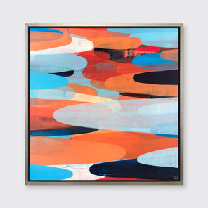 A orange, light blue, red and black abstract print in a silver floater frame hangs on a white wall.