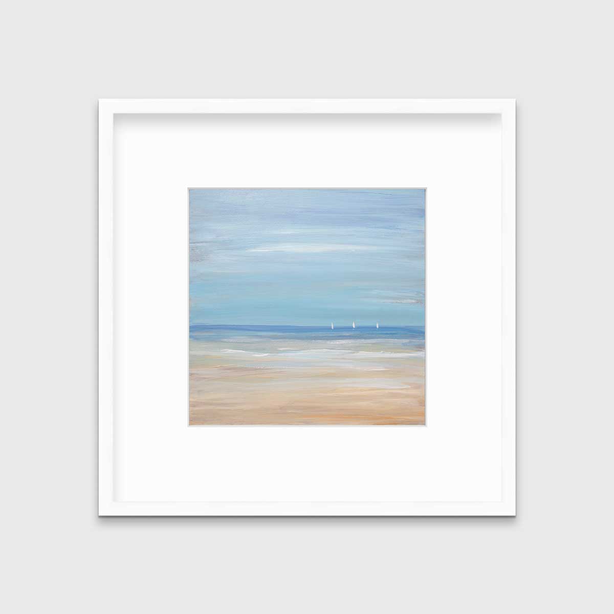 A blue, beige and white abstract seascape print with three small sailboats in a white frame with a mat hangs on a white wall.