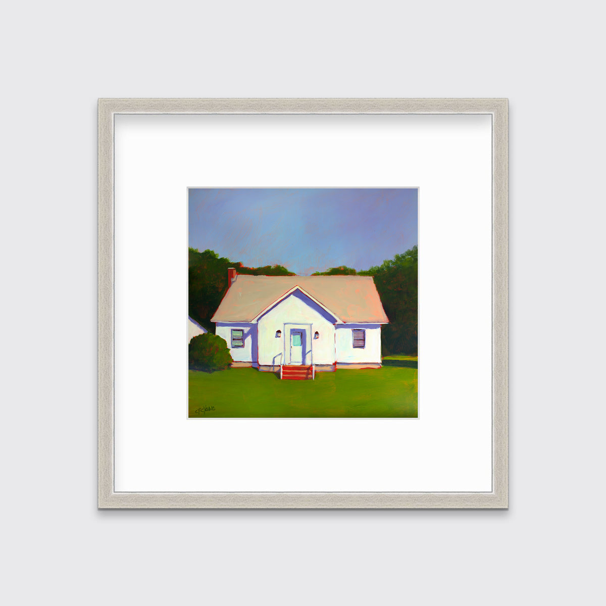 A blue, white and green contemporary house print in a silver frame with a mat hangs on a white wall.
