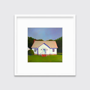 A blue, white and green contemporary house print in a white frame with a mat hangs on a white wall.