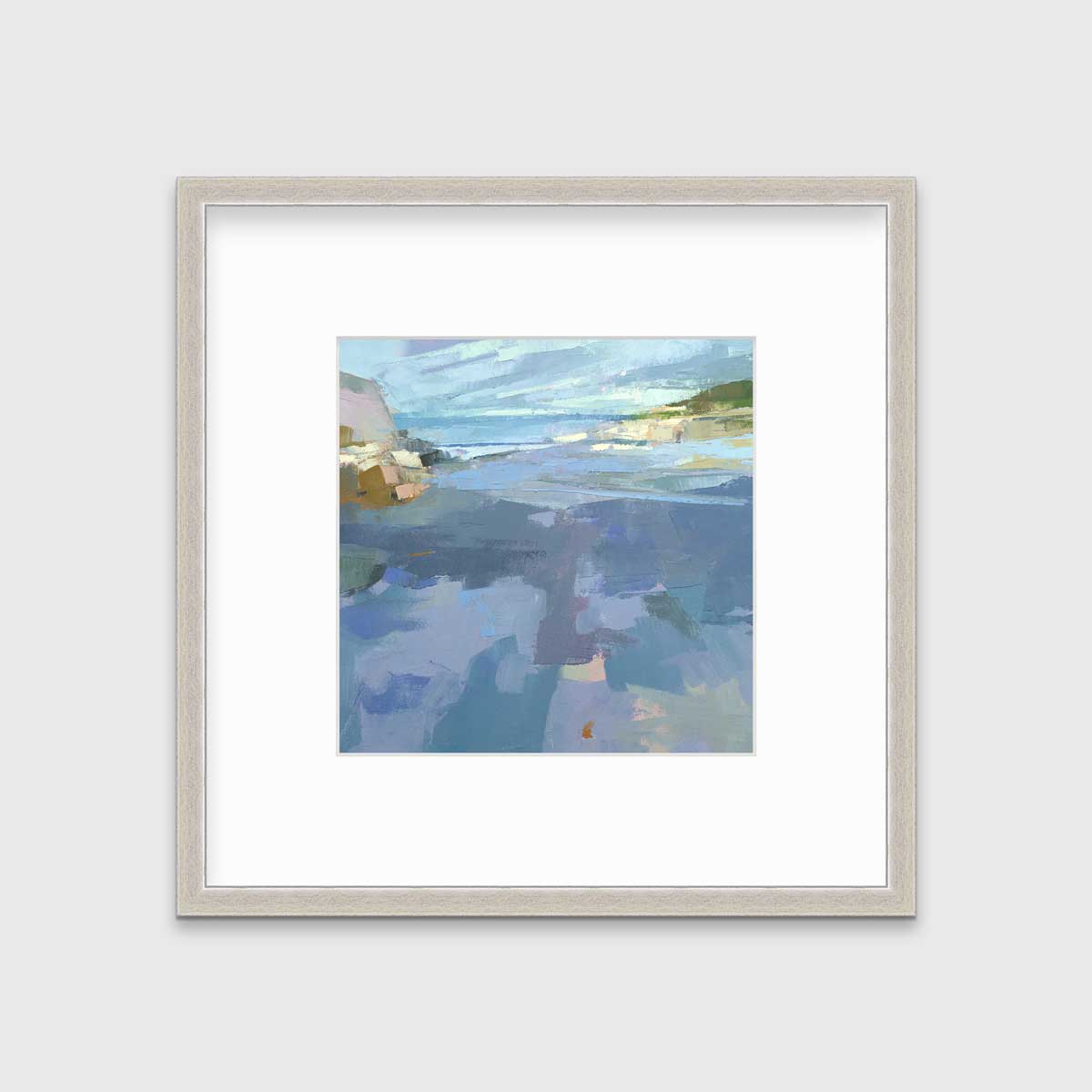 A blue, purple and green abstract landscape print in a silver frame with a mat hangs on a white wall.