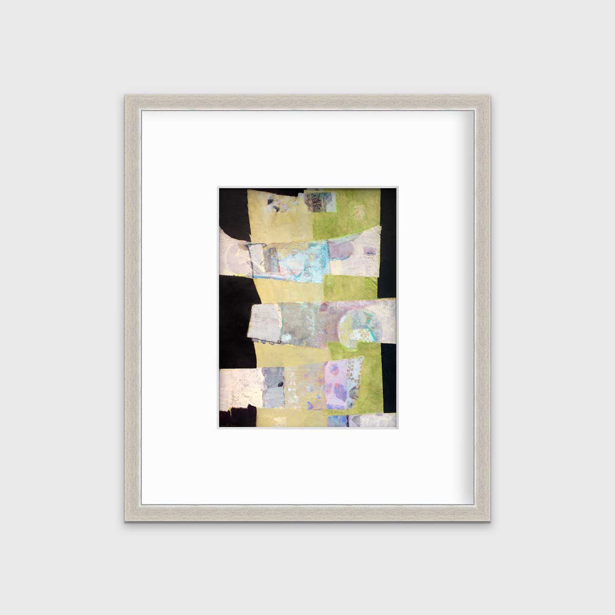 A green, black and beige abstract print by Christine Averill-Green in a silver frame with a mat hangs on a white wall.