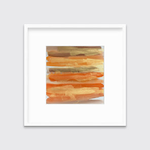 A gold, orange and light brown abstract print in a white frame with a mat hangs on a white wall.