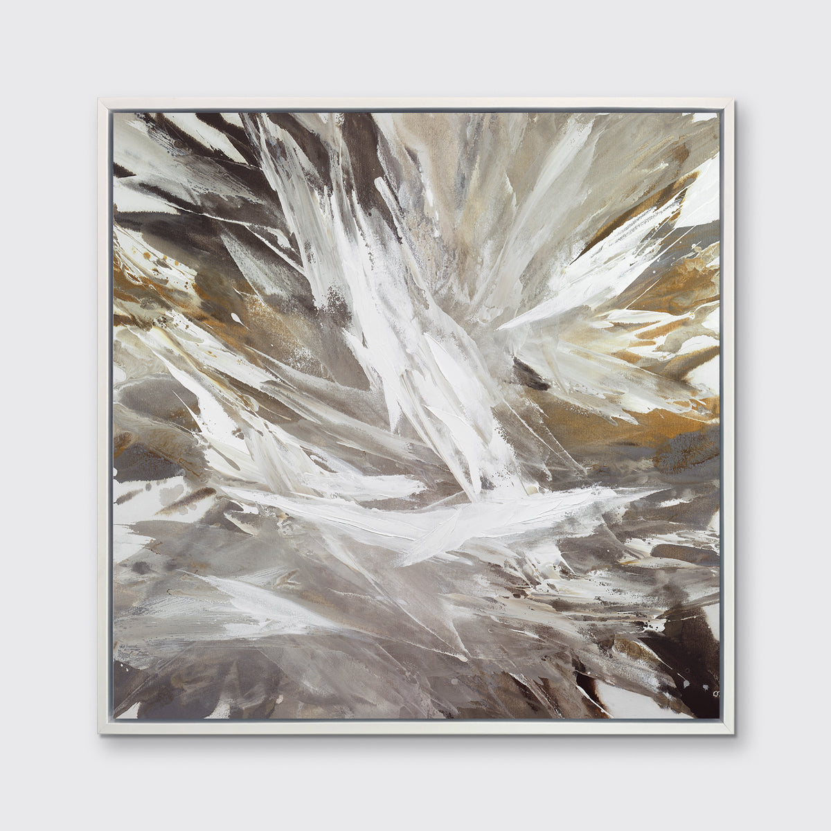 A white, grey, dark grey and gold abstract print in a white floater frame hangs on a white wall.