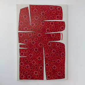 A large abstract painting of an irregular red form containing yellow and white circles is hung on a gallery wall.