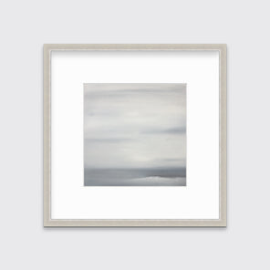 A tonal grey print in a silver frame with a mat hangs on a white wall.