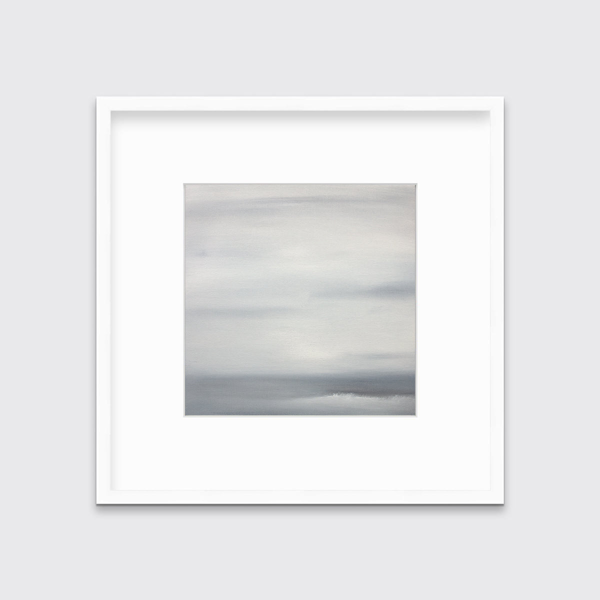 A tonal grey print in a white frame with a mat hangs on a white wall.