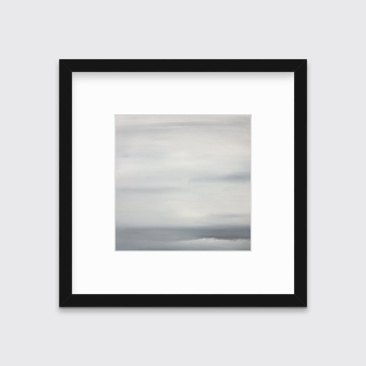 A tonal grey print in a black frame with a mat hangs on a white wall.