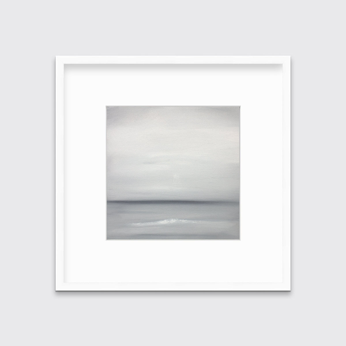 A tonal grey abstract print in a white frame with a mat hangs on a white wall.